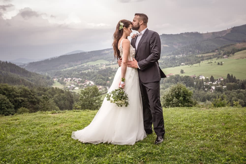 Nevěsta a ženich svatba na louce v Beskydech v pozadí hory